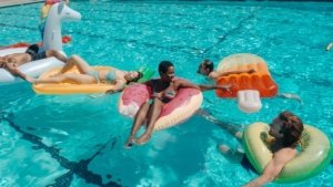family swimming on floaties in a swimming pool