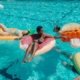 family swimming on floaties in a swimming pool
